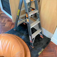 Load image into Gallery viewer, An electrician has a large tidy tradie work mat under his ladder to keep the floor clean and protected

