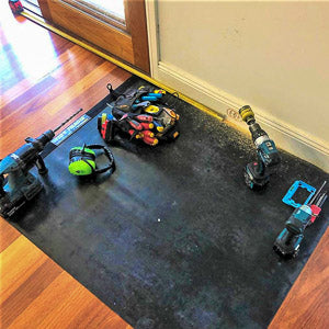 Electrician cutting out for a power point while using a large tidy tradie work mat to protect the floor