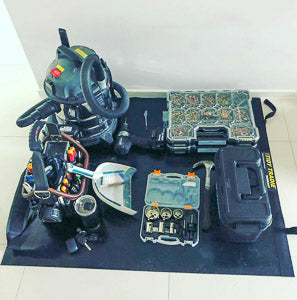 An electrician keeping tools neatly on a large tidy tradie work mat to protect the work area.