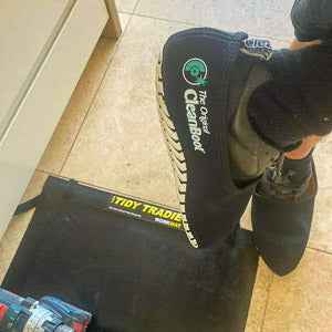Plumber showing the tidy tradie combo. Medium size work mat and large size cleanboot.