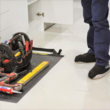 Load image into Gallery viewer, Plumber wearing cleanboots and using a medium tidy tradie work mat to place his tools on.
