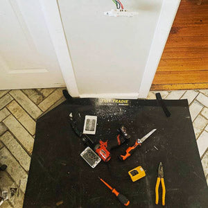 Electrician keeping his tools neatly on a large tidy tradie work mat while protecting the floor