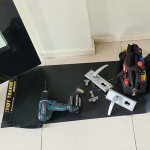 A locksmith keeping his tools neatly on a small tidy tradie work mat