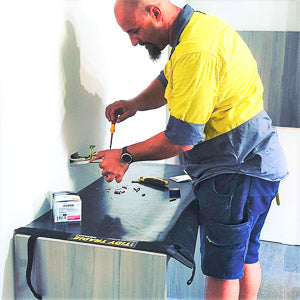 Electrician using a Tidy Tradie work mat to protect the clients property.