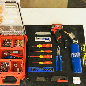 An electrician keeping his tools neatly on a medium tidy tradie work mat to protect the kitchen bench top.